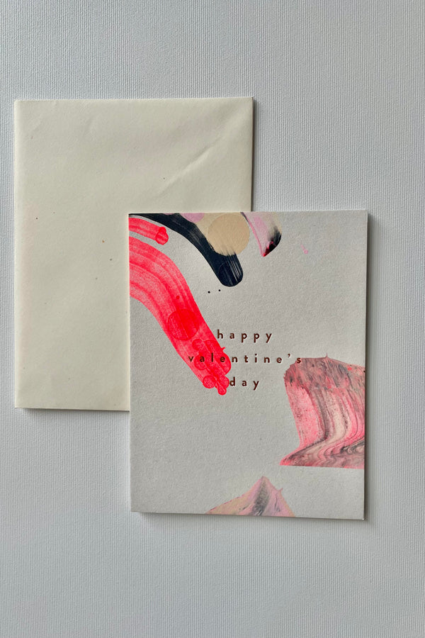 Photo of a handpainted Valentine Swirl greeting card and envelope in a white room.