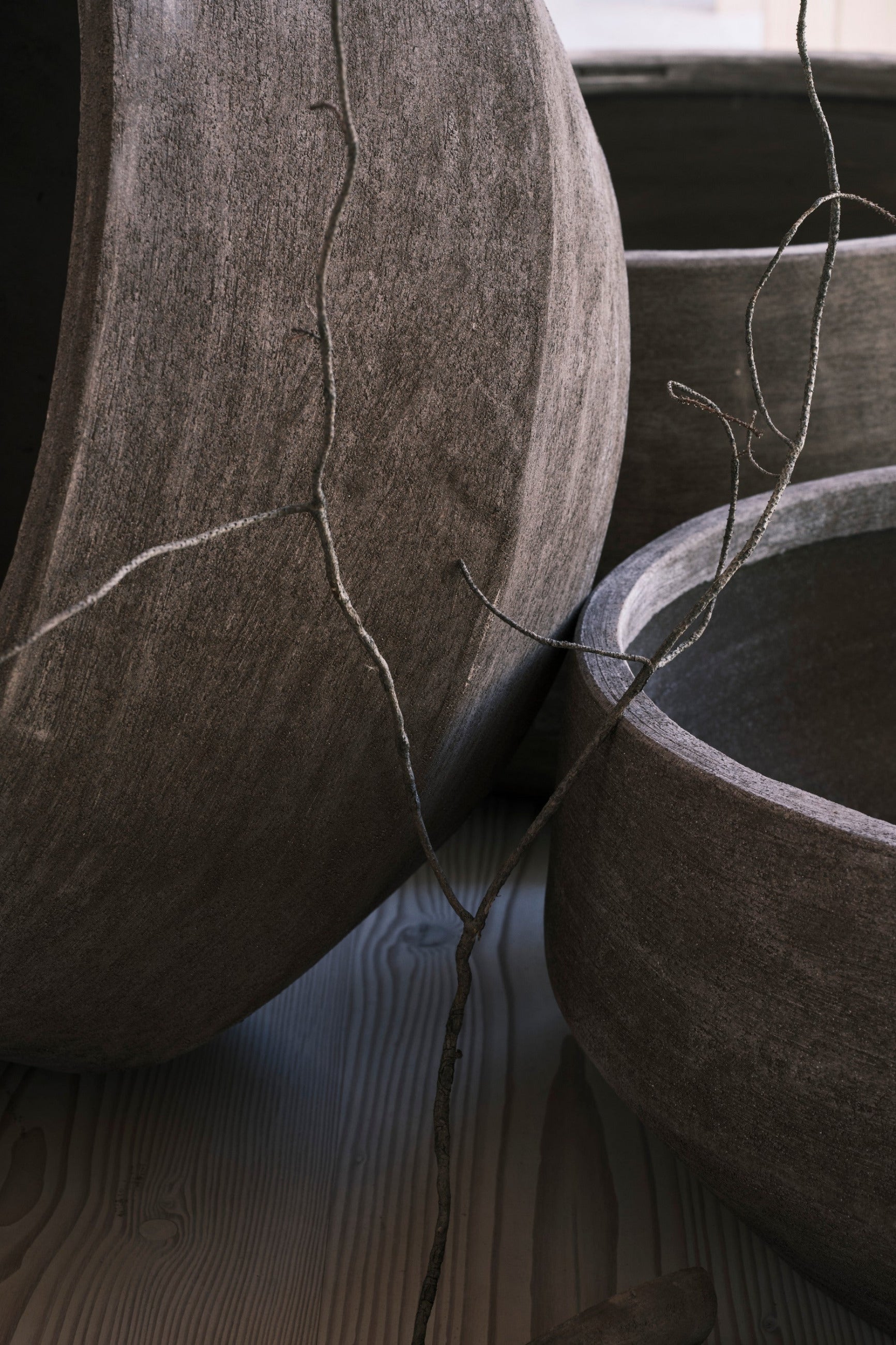 Doma Grey planters on a wooden surface with a branch. ©Bergs Potter