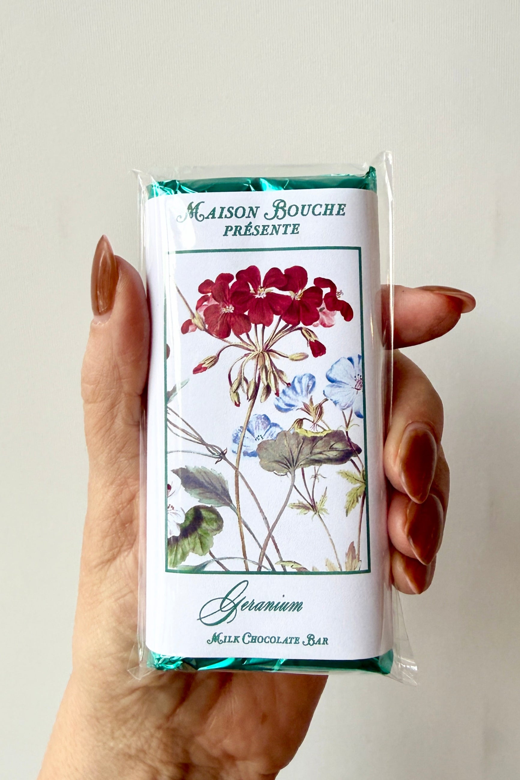 Hand holding a Maison Bouché chocolate bar with floral design ©Sprout Home