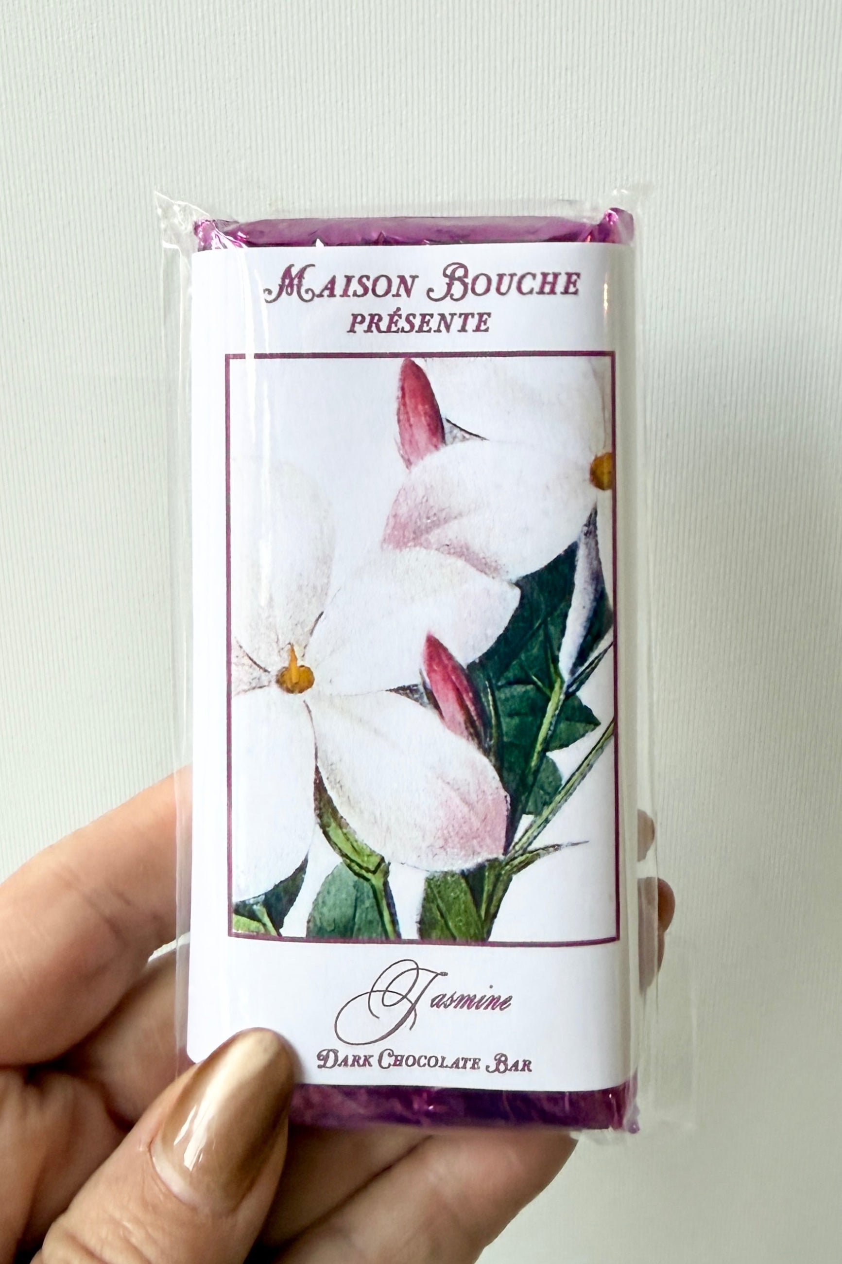 Maison Bouchee chocolate bar packaging with jasmine floral design held by a hand. ©Sprout Home