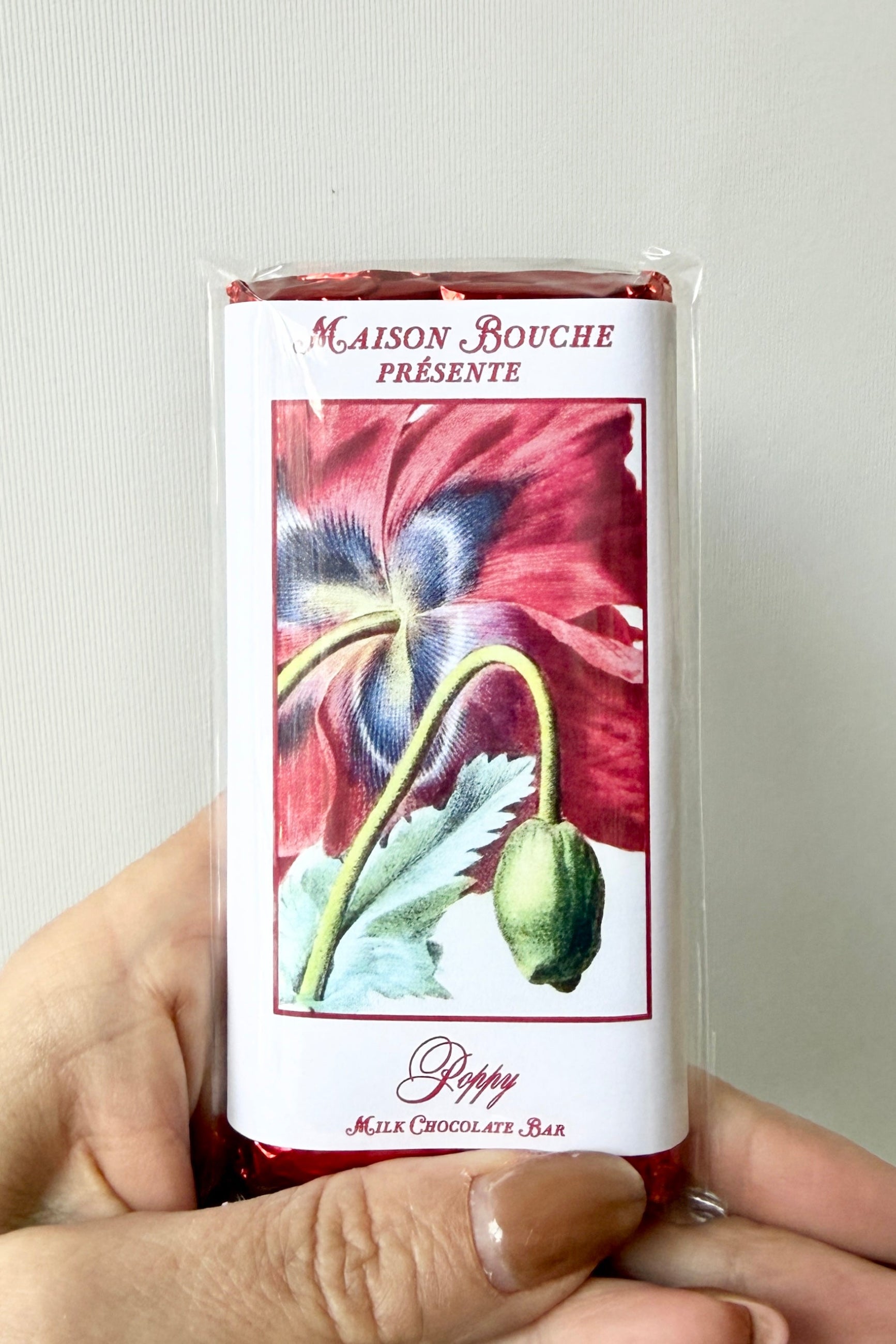 Maison Bouche milk chocolate bar packaging held by a hand against a light background ©Sprout Home