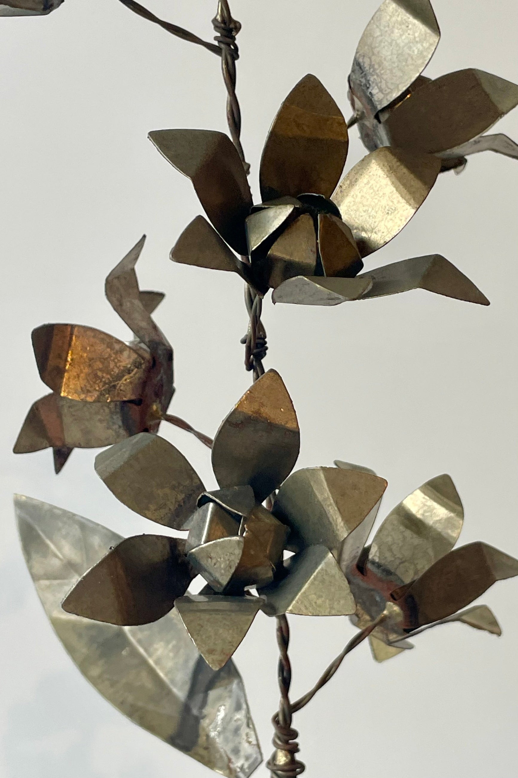 A spray of metal flowers in front of a white wall ©Sprout Home
