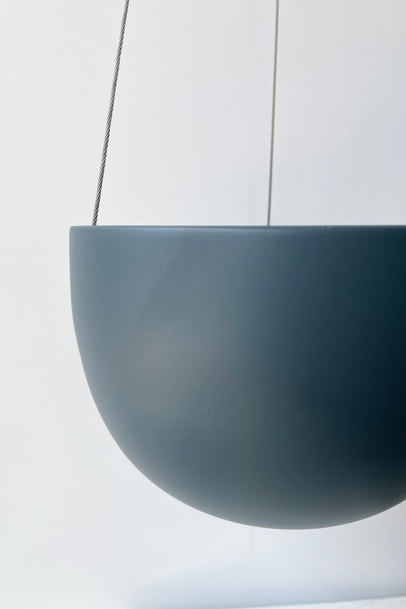 a close up of the finish on the clifton matte deep blue hanging pot small against white. 