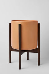 LBE Design peach cylinder pot with dark teak stand.