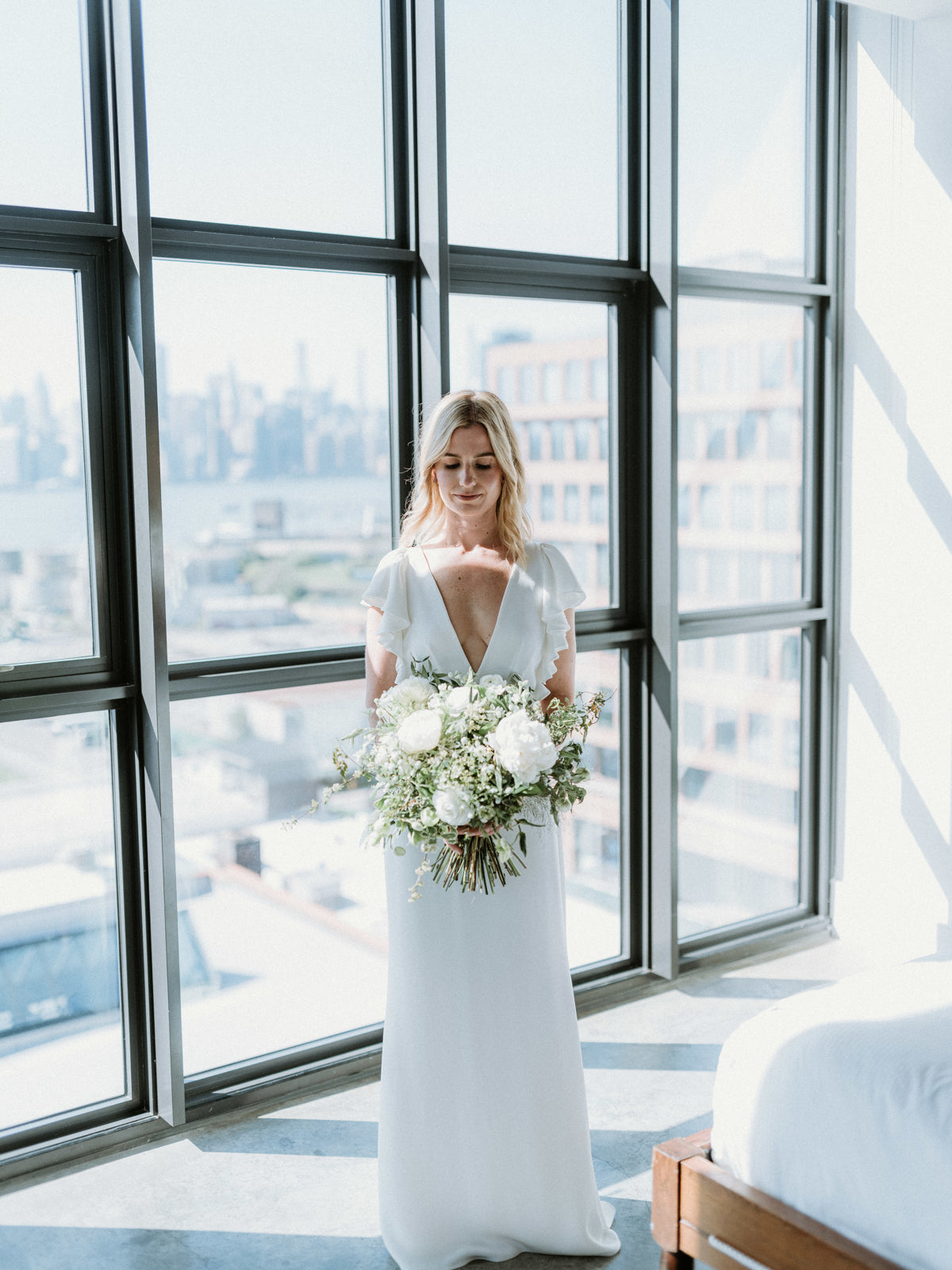 Lucas wedding with the bride holding a white bouquet from Sprout Home. Photography by Forged in the North