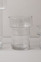 Medium size clear glass Keeper vase in an off-white setting empty and a sliver of other vases of to each side.