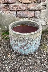 Photo of a Medium Coarse Volcano Glaze pot with a heavily textured glaze. Shown outdoors on a paved surface against a brick wall. Shown from above.