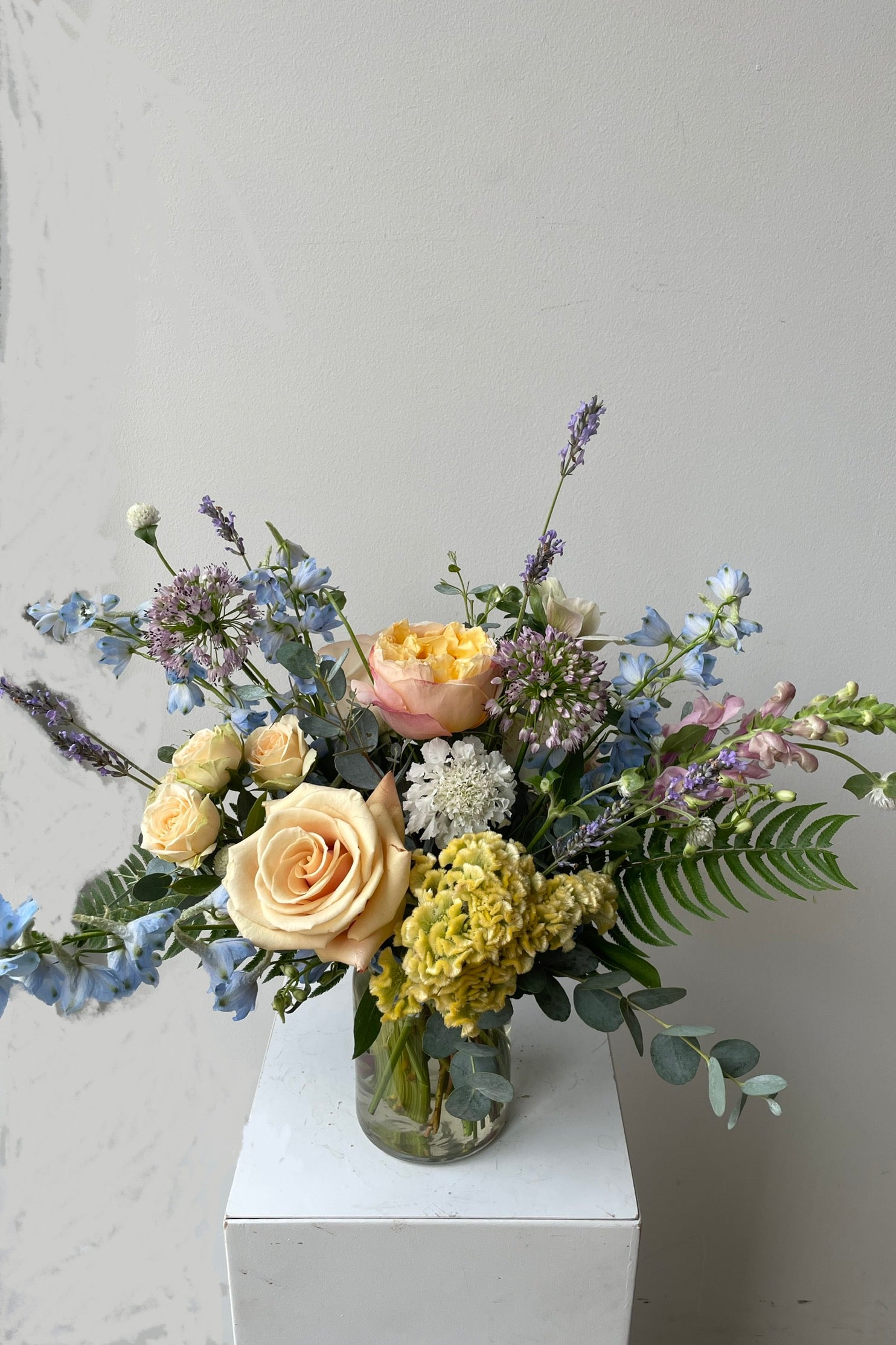 sprout Home Dawn arrangement middle of August with peach roses and blue delphiniums. #size_$90