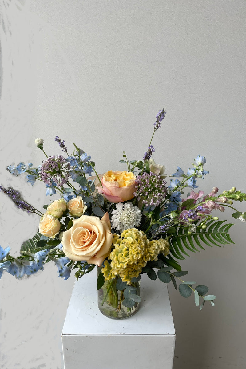 sprout Home Dawn arrangement middle of August with peach roses and blue delphiniums.