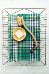 The Helen kitchen Cloth by Fog Linen Work sitting flat in a drying rack with a brush and bowl of soap.