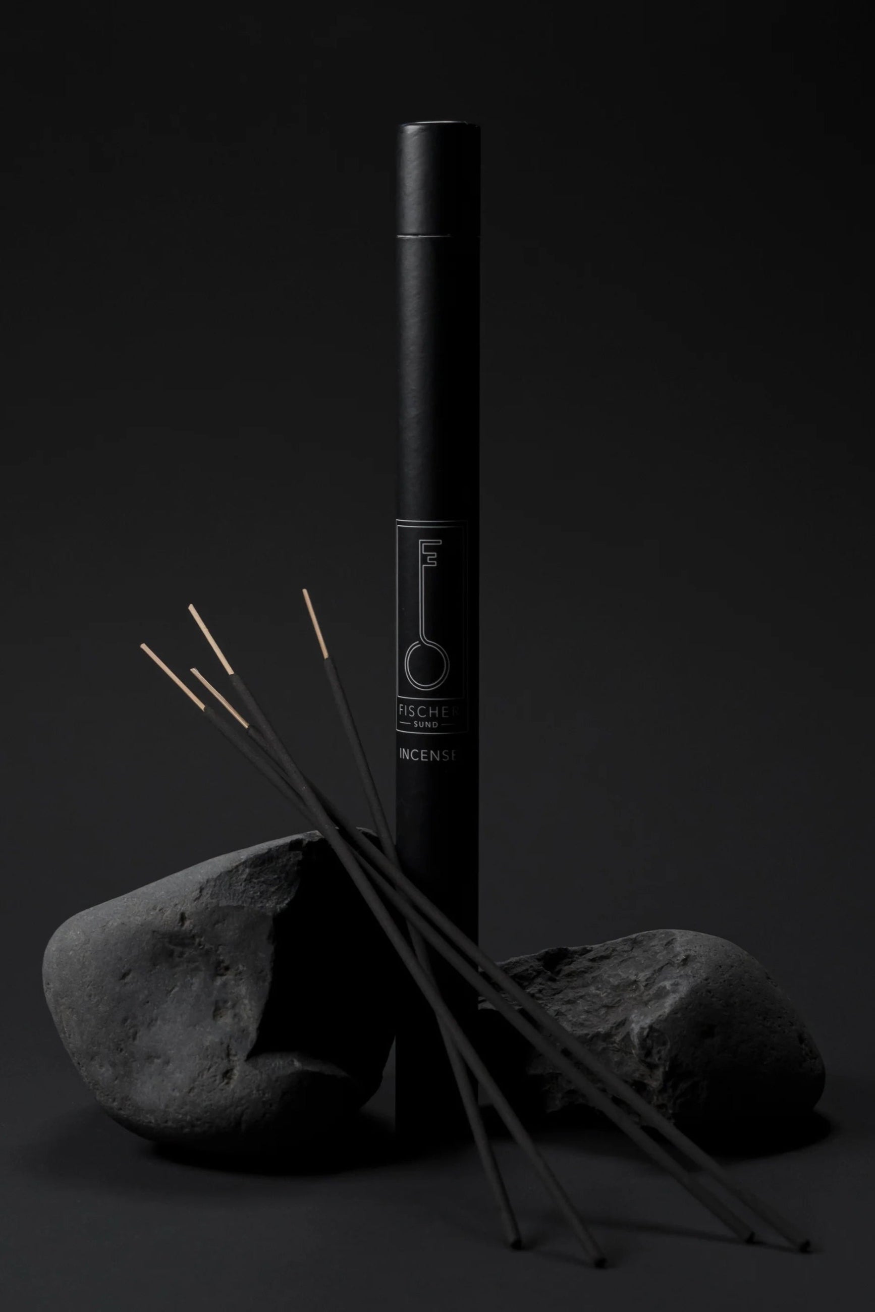 Fischersund Incense Sticks with the tube packaging and sticks laying on rocks in front ©Fischersund