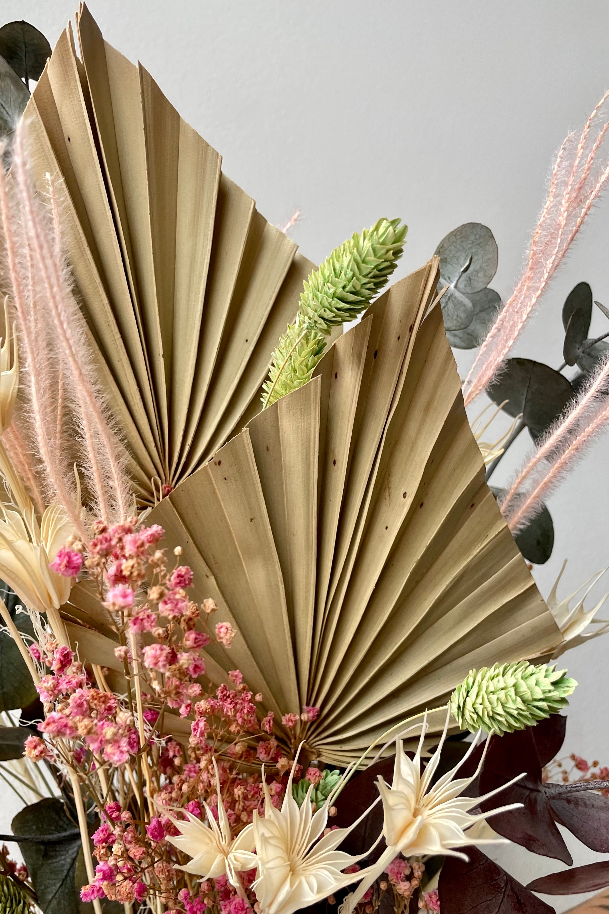 Detail of the Sprout Home Faerie arrangement showing the dried neutral palm, pink gypsophila, green phalaris and white nigella. #size_$60