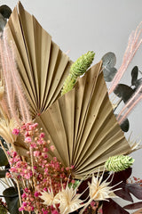 Detail of the Sprout Home Faerie arrangement showing the dried neutral palm, pink gypsophila, green phalaris and white nigella