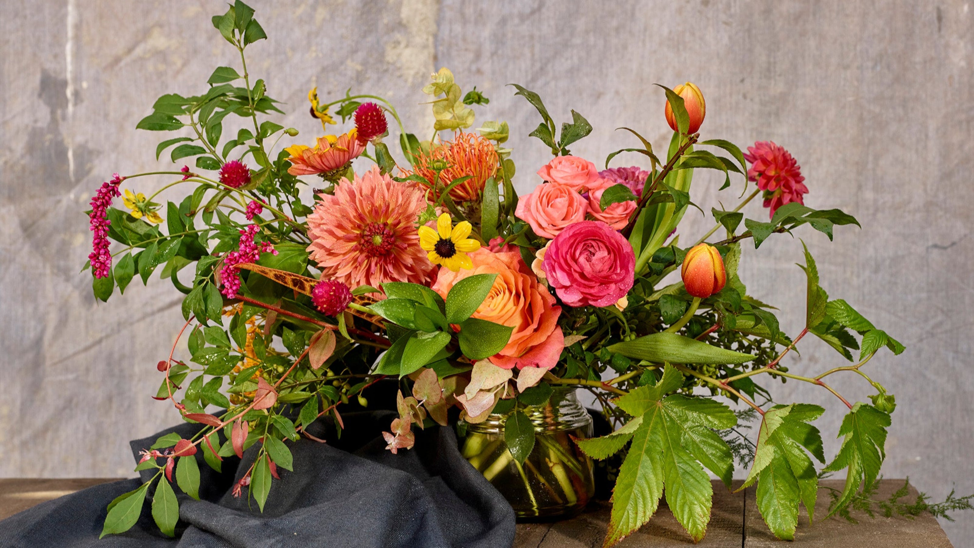 Mid day table arrangment with pink and peach roses, dahias and greenery ©Sprout Home