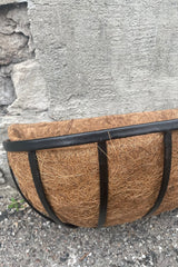 A detailed view of the Forge Wall Trough with Coco Liner 24" against concrete backdrop