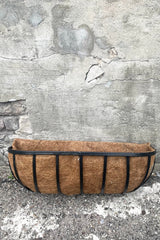 A full frontal view of Forge Wall Trough with Coco Liner 24" against concrete backdrop