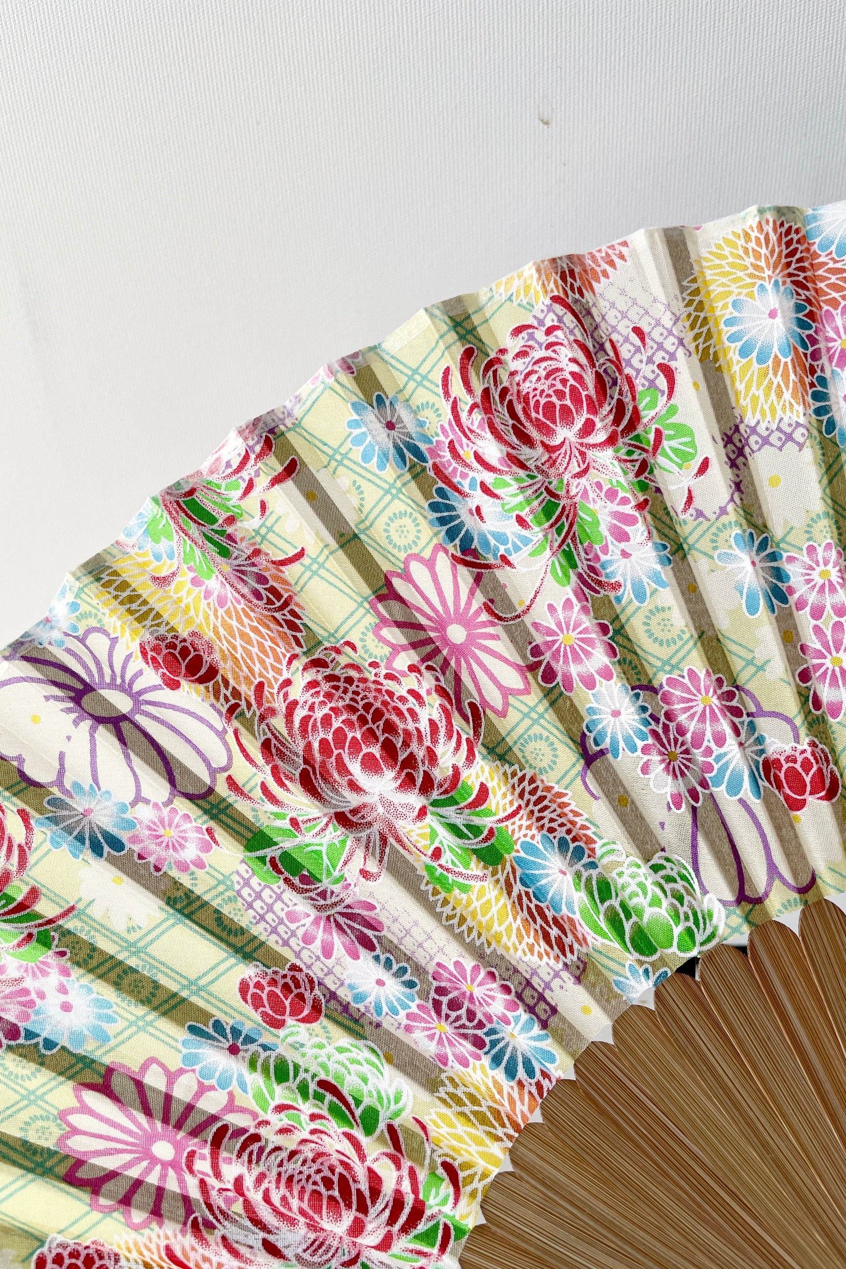 Silk fan pale green with chrysanthemums  showing a detail of the pattern. ©Sprout Home