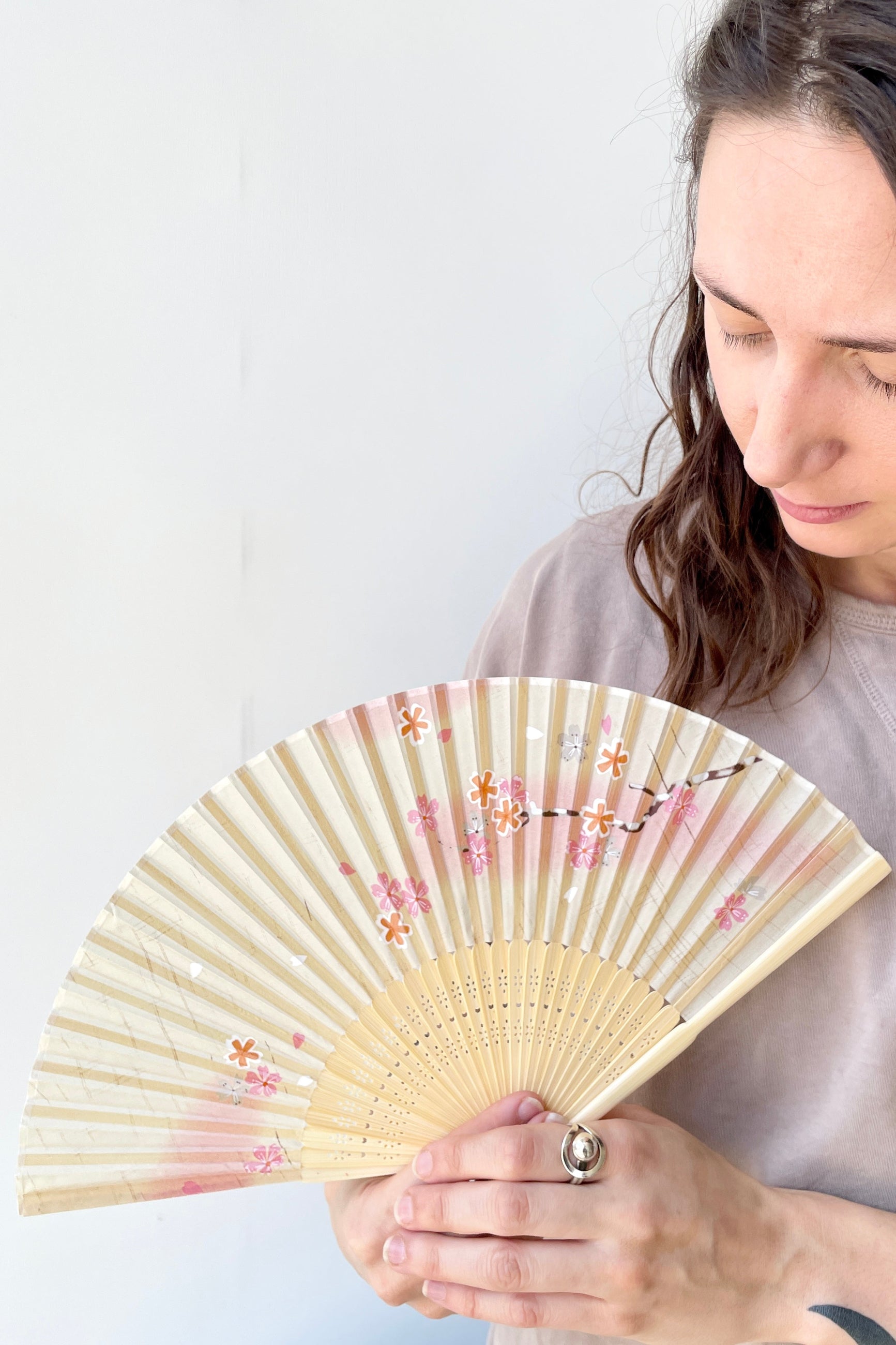 Silk fan white and pink cherry blossoms being held by a Sprout Home team member ©Sprout Home