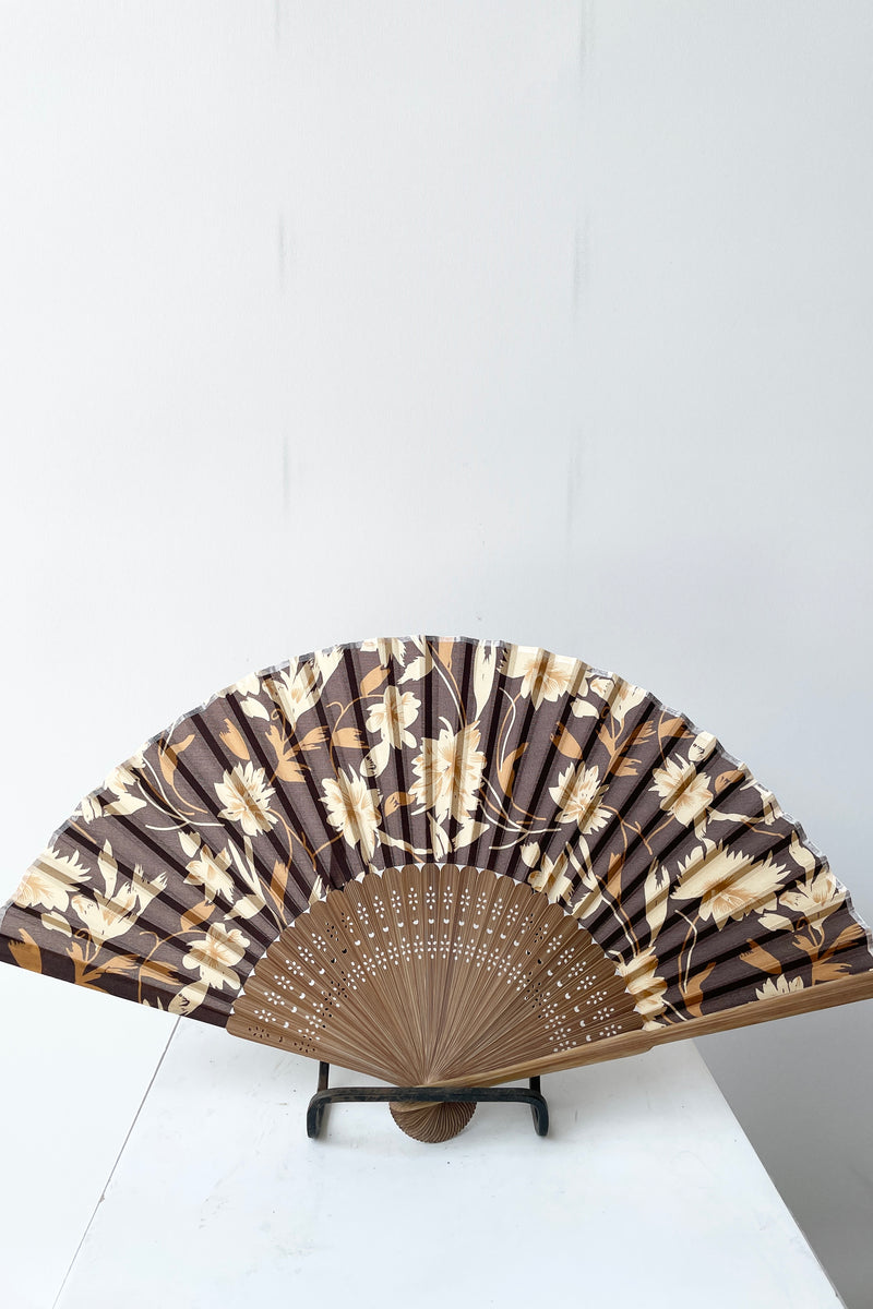 Silk fan brown flower and brown bamboo open and on a stand at Sprout Home. 