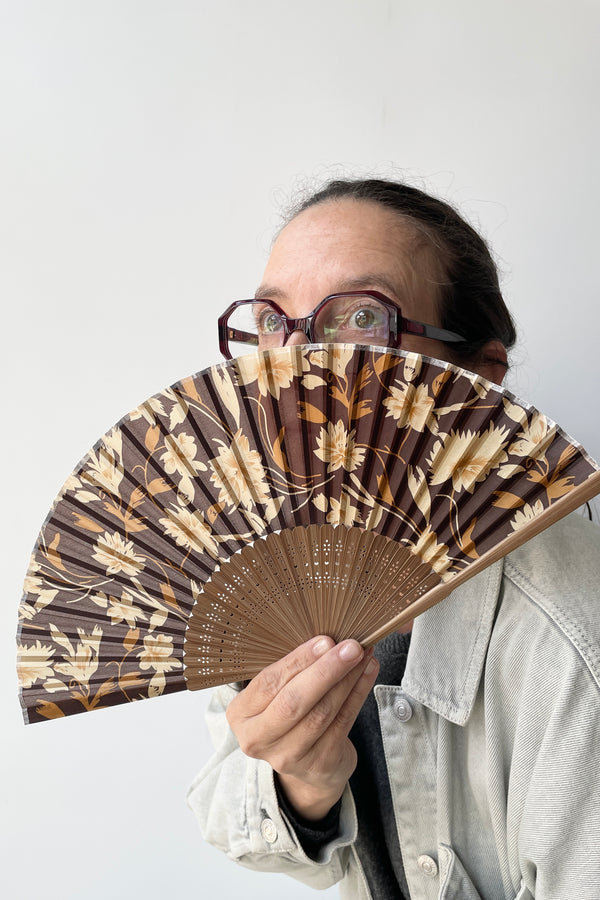 Silk Fan brown flowers with brown bamboo being held by Tara at Sprout Home.