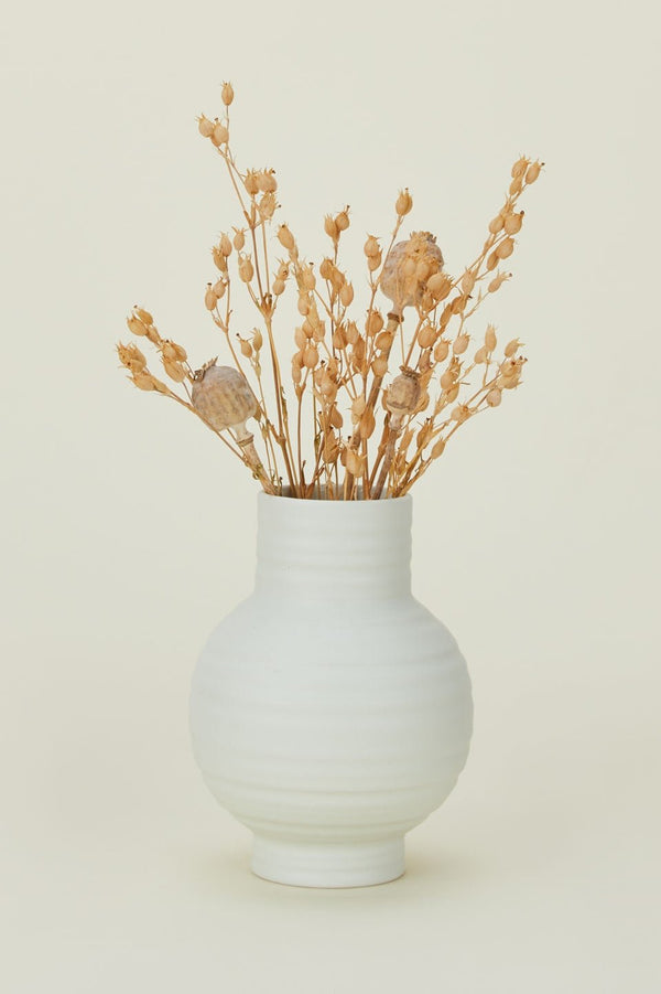 Bone colored Essential vase with some dried floral inside by Hawkins New York. 