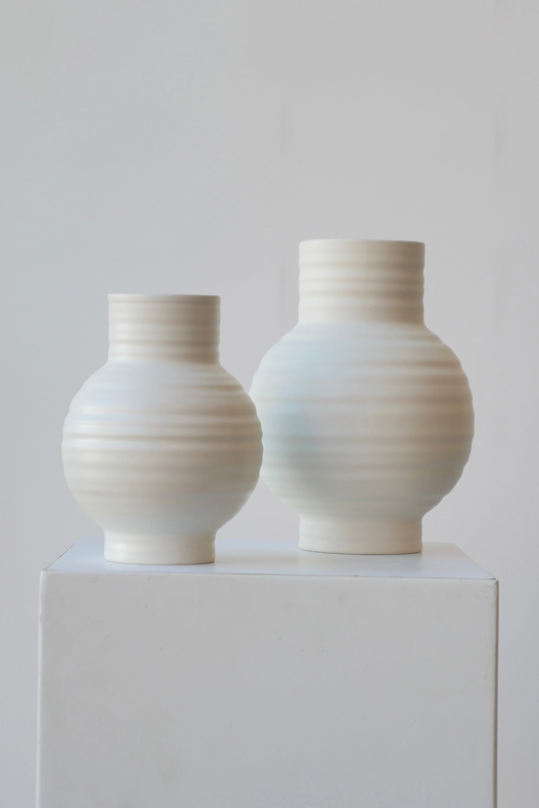 A pair of small and large essential ceramic vases in the color Bone by Hawkins New York at Sprout Home.   ©Sprout Home