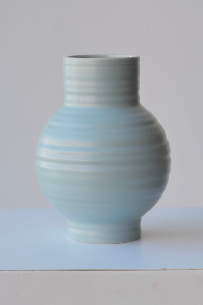 A small size Sky colored Essential ceramic vase by Hawkins NY viewed from the side at eye level. 