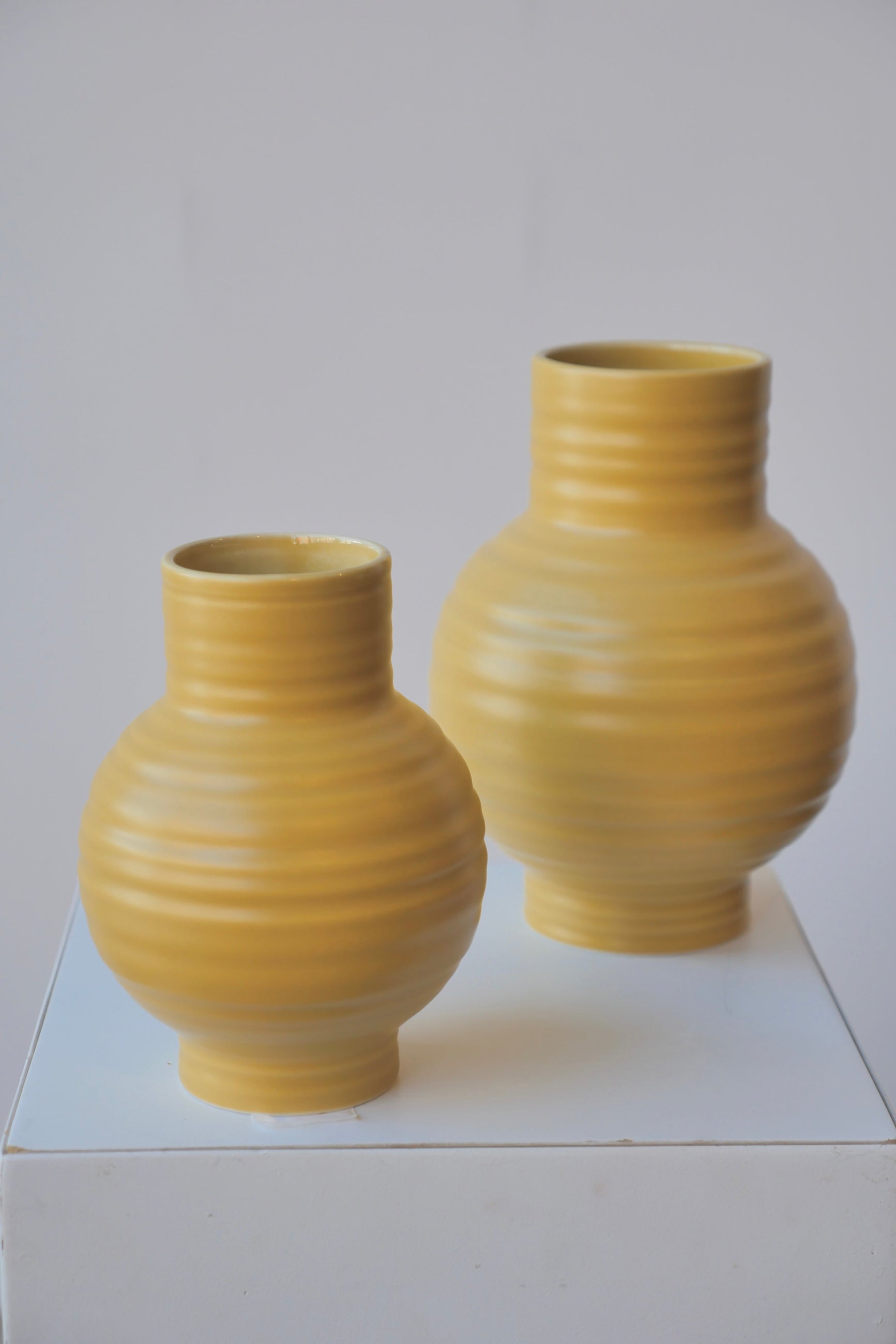 A pair of Essential Vases by Hawkins NY in Mustard with the small size in front.  ©Sprout Home