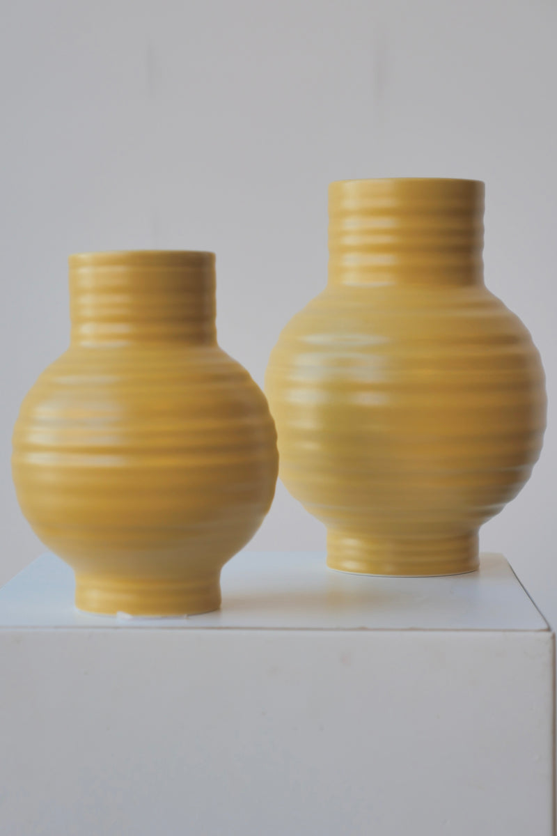 A pair of Mustard Essential ceramic vases at eye level against white. 