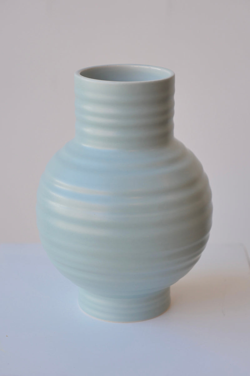 A Hawkins NY Essential Sky vase showing its bulbous form against a white wall. 