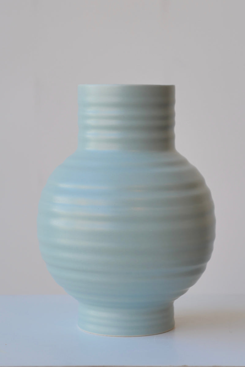 Sky colored Essential vase by Hawkins NY viewed from eye level showing is horizontal ridges. 