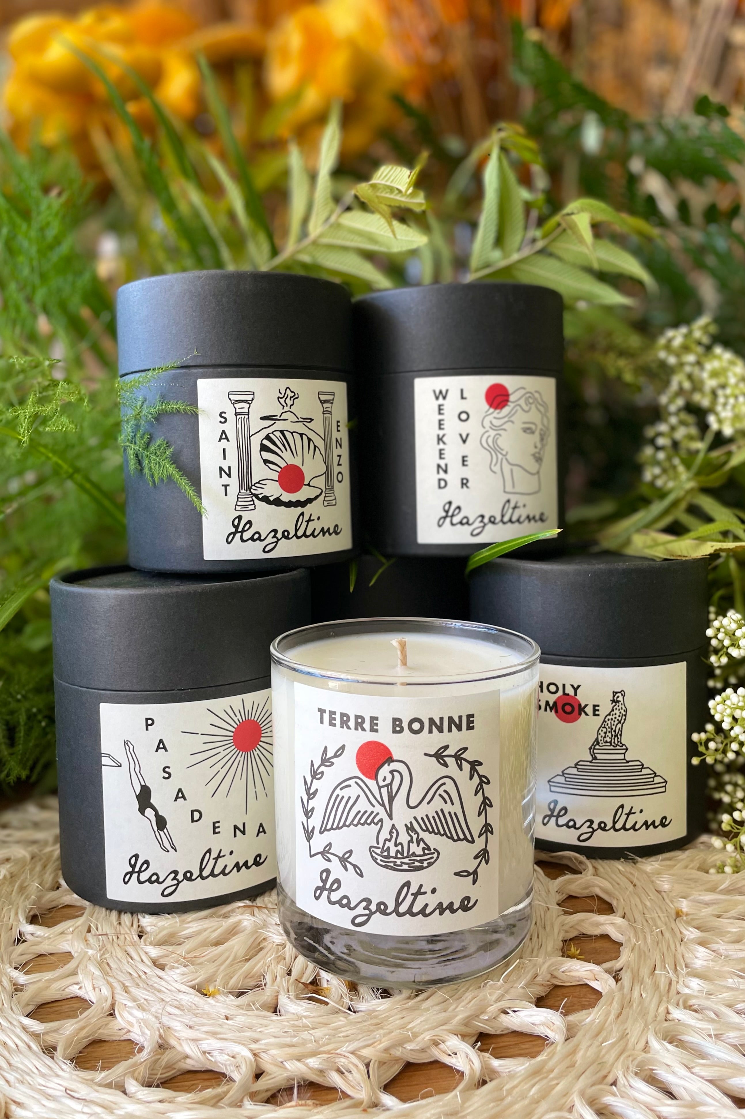 Hazeltine candles grouped together on display and stacked. 