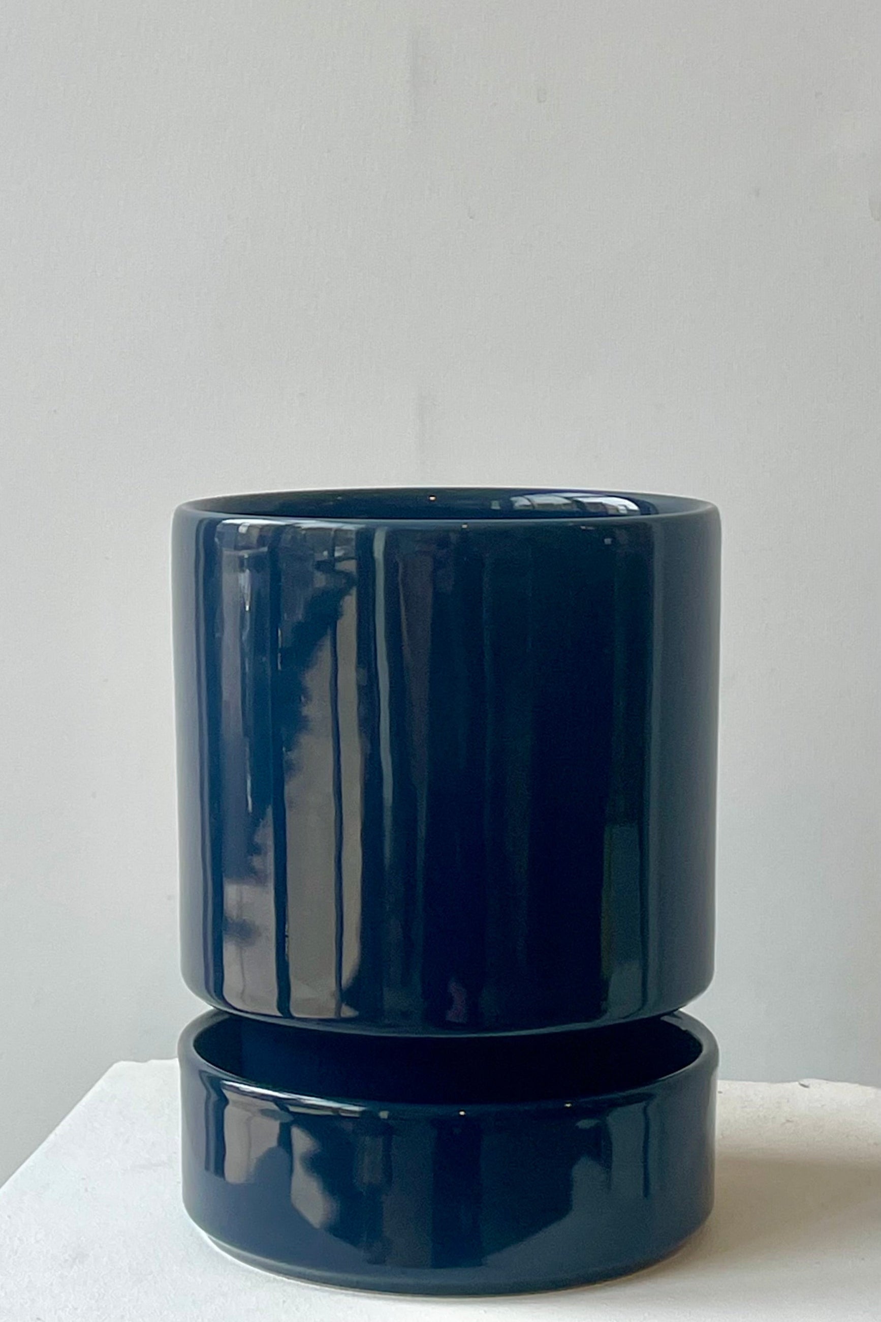 A sapphire blue hoff pot and saucer in front of a white wall ©Sprout Home