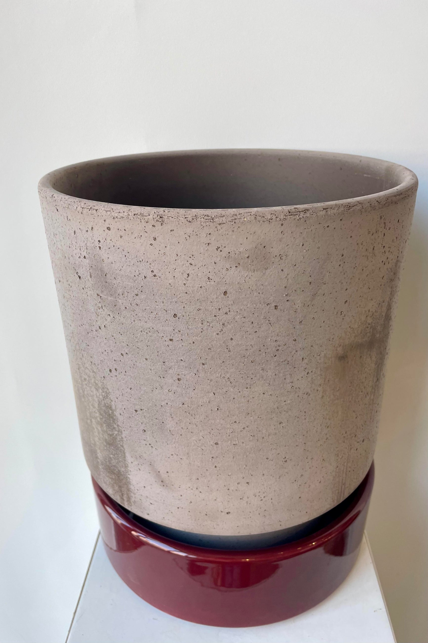 Hoff Pot by Bergs Potter with a glazed burgundy saucer and gray textured pot ©Sprout Home