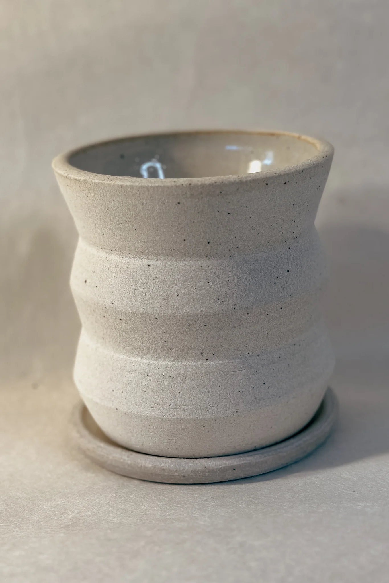 Creme Angled 4x4 Planter by Olivia Snow Ceramics, empty and shown from the side on a neutral background. ©Olivia Snow Ceramics
