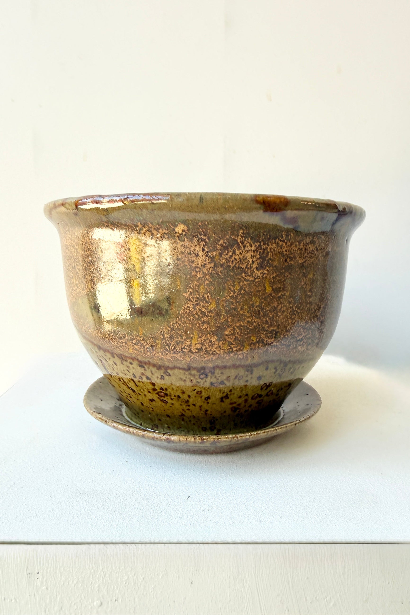 Ceramic 4" Bruning pot in an Army Green with Yellow speckled glaze on a stone surface. ©Sprout Home