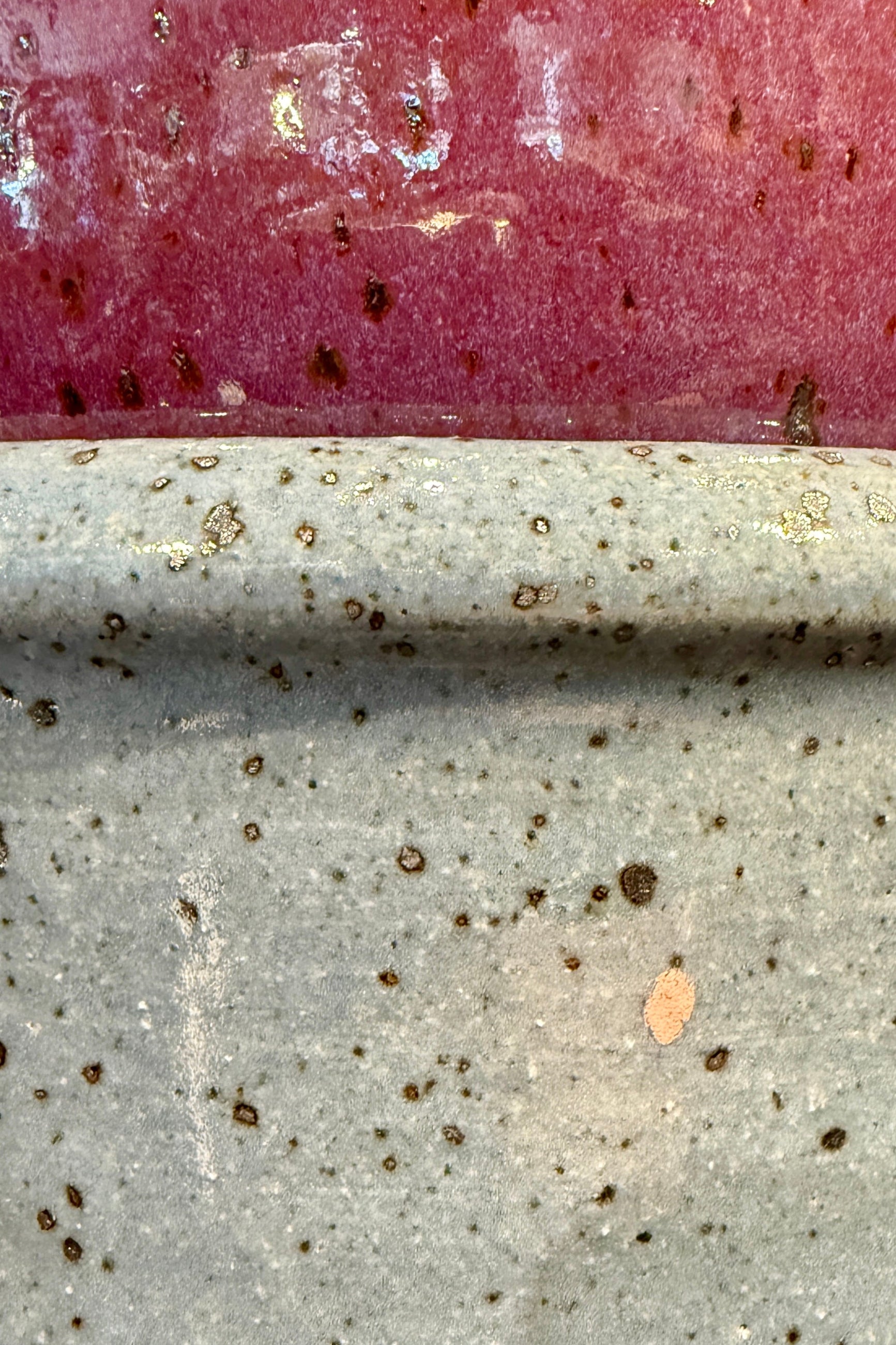 Close-up of two glazed ceramics, one bright pink and one white from Bruning Pottery ©Sprout Home