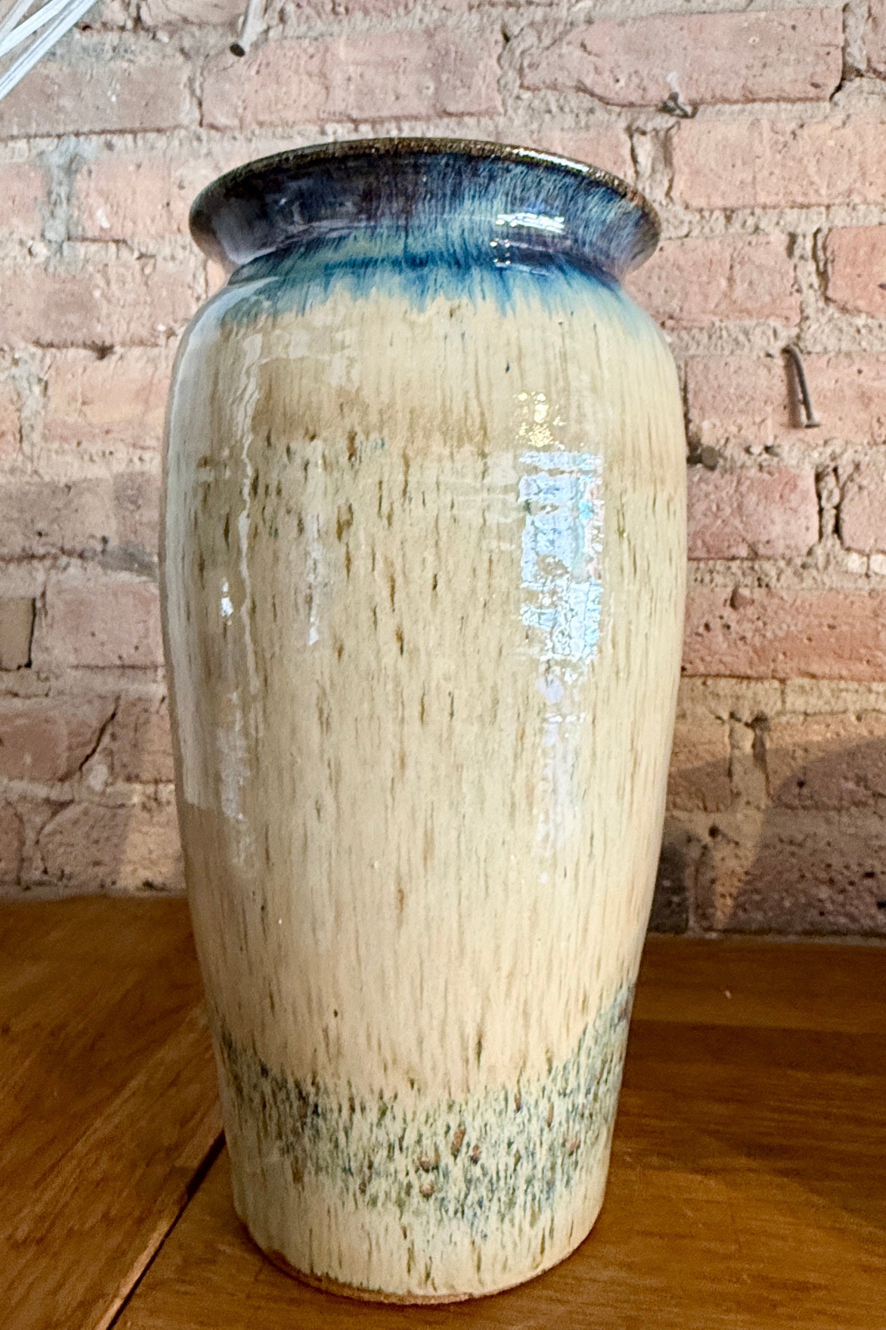 Bruning Pottery Tall ceramic vase with blue and green glaze against a brick wall background ©Sprout Home