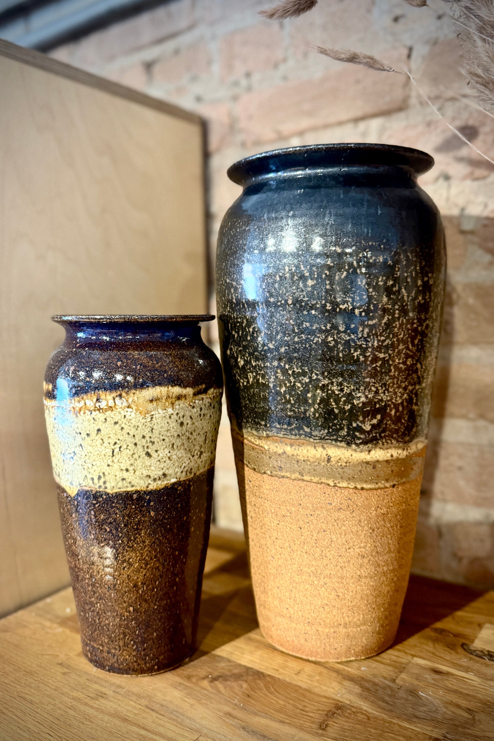 Two Bruning Pottery ceramic vases with a speckled glaze on a wooden surface at Sprout Home Floral ©Sprout Home