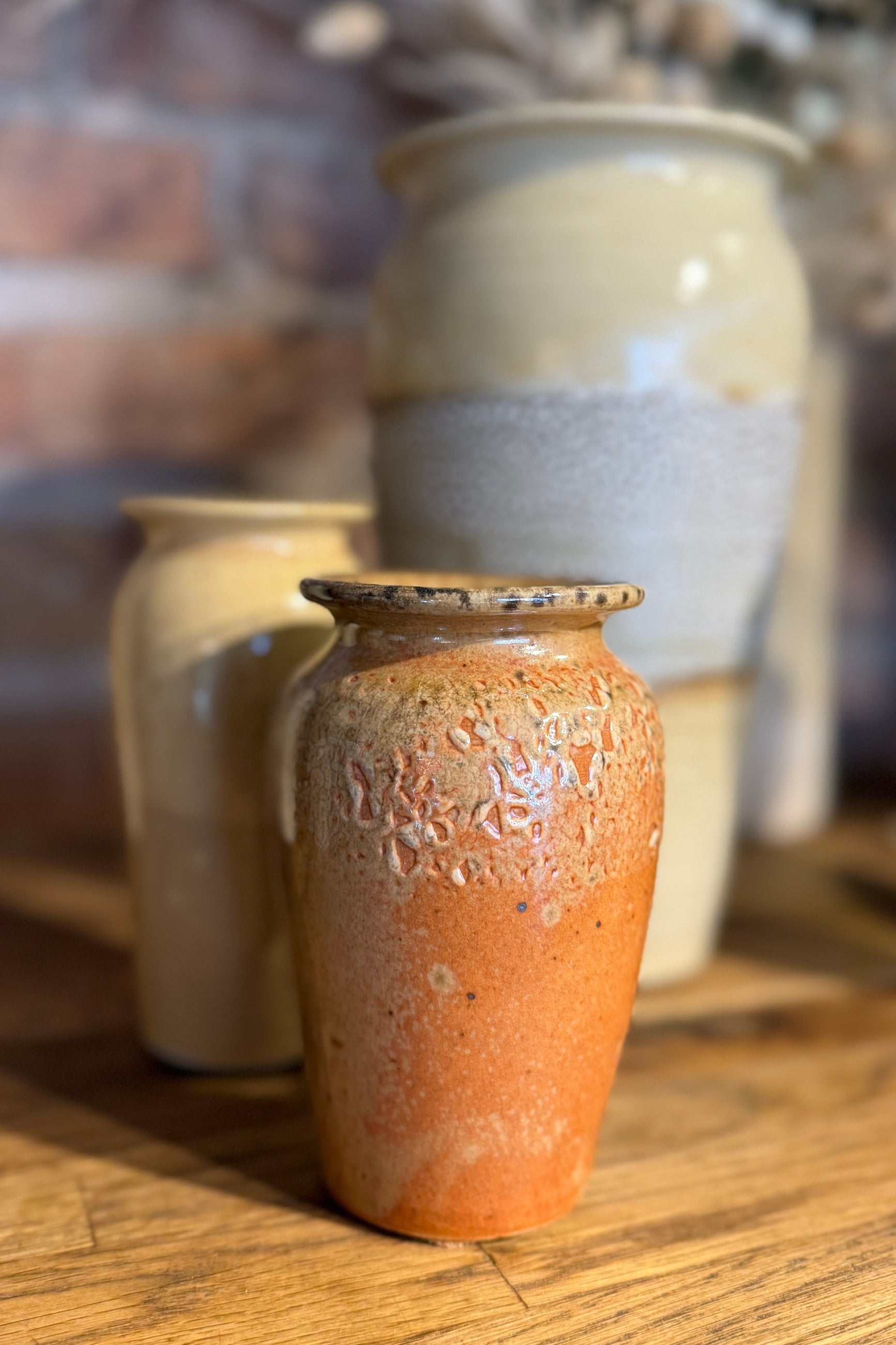 Bruning Pottery Vases with a deep orange In front of ivory ones ©Sprout Home