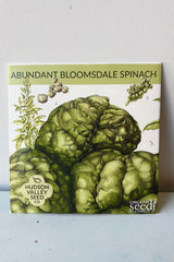 Seed pack of Abundant Bloomsdale Spinach against white wall