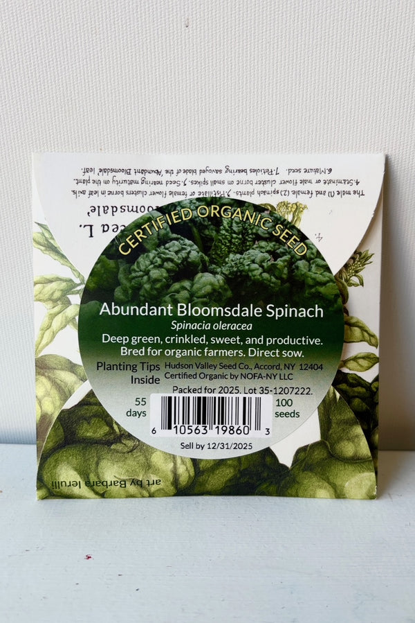 Backside of Abundant Bloomsdale Spinach seed pack against white wall