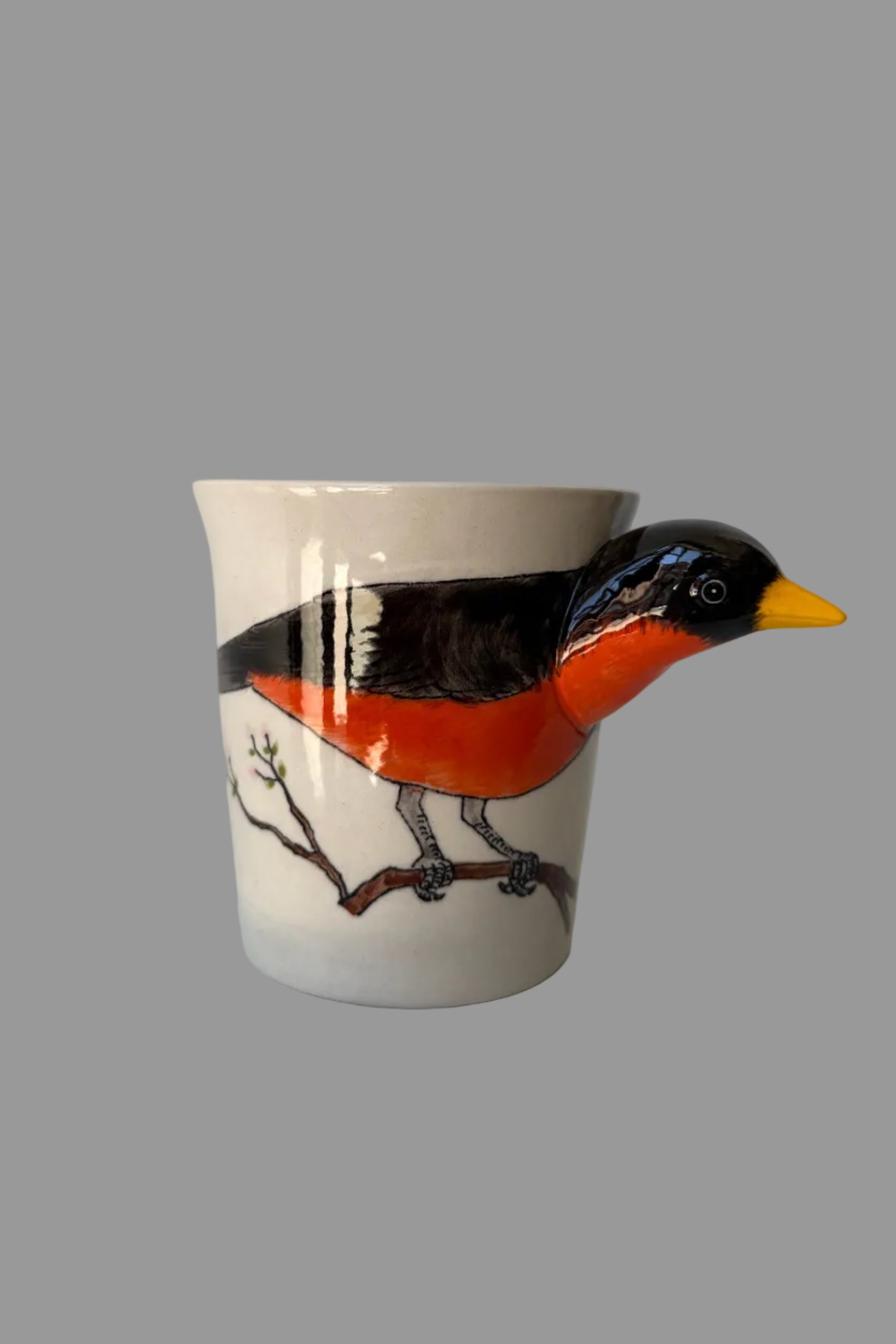 Ceramic mug with a painted bird design on a white surface ©Sprout Home