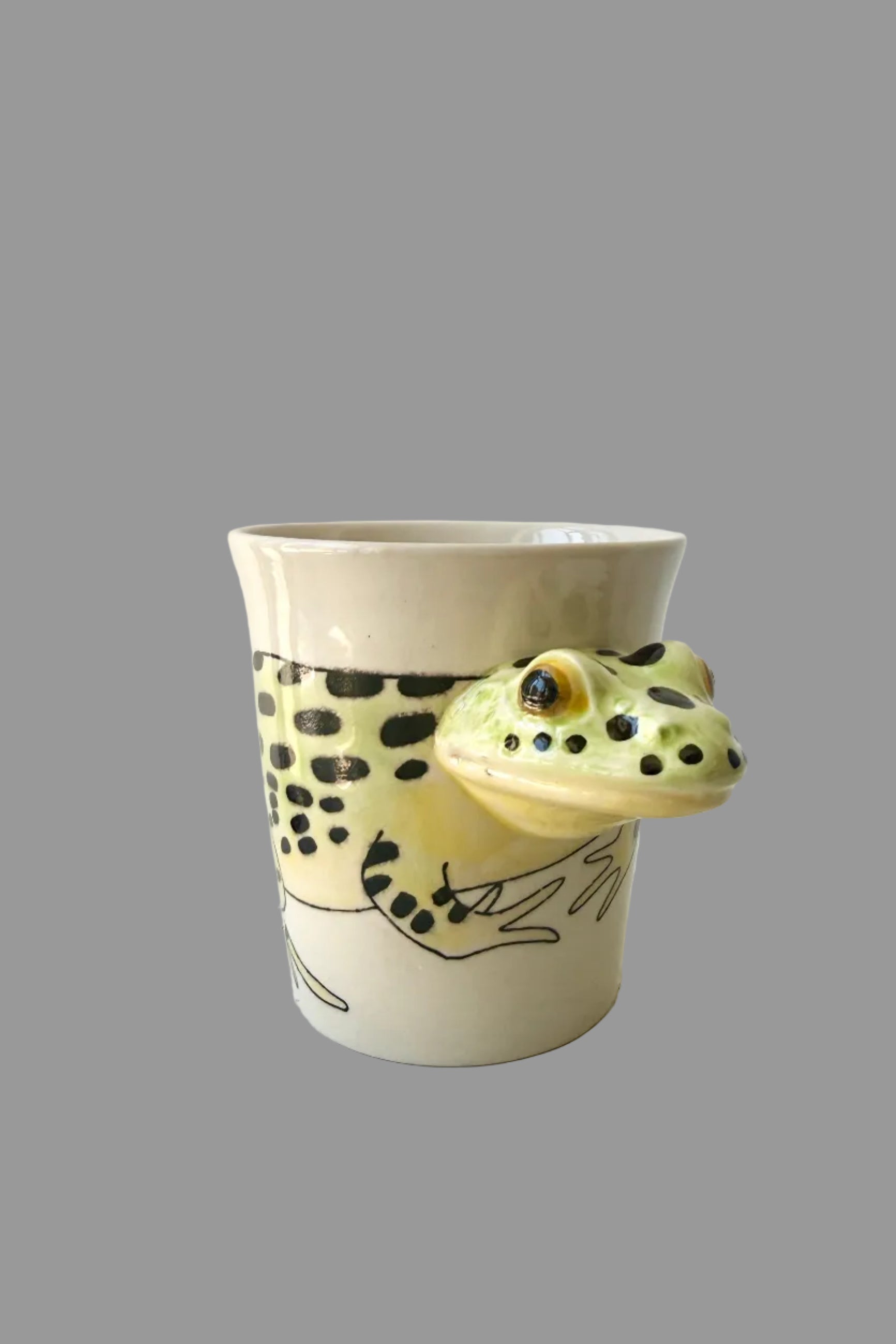 Ceramic mug with a Frieda the frog design on a gray surface ©Sprout Home