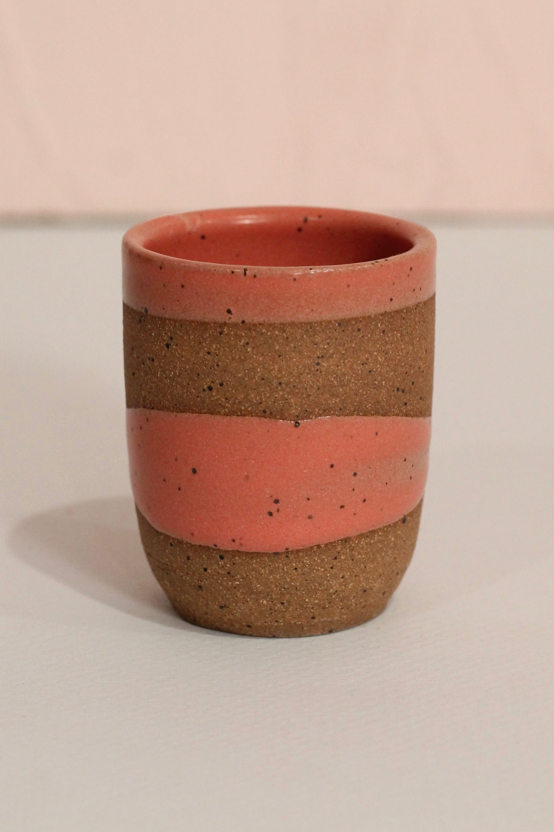 Ceramic cup with two-tone design on a plain background ©Christina Kosinski