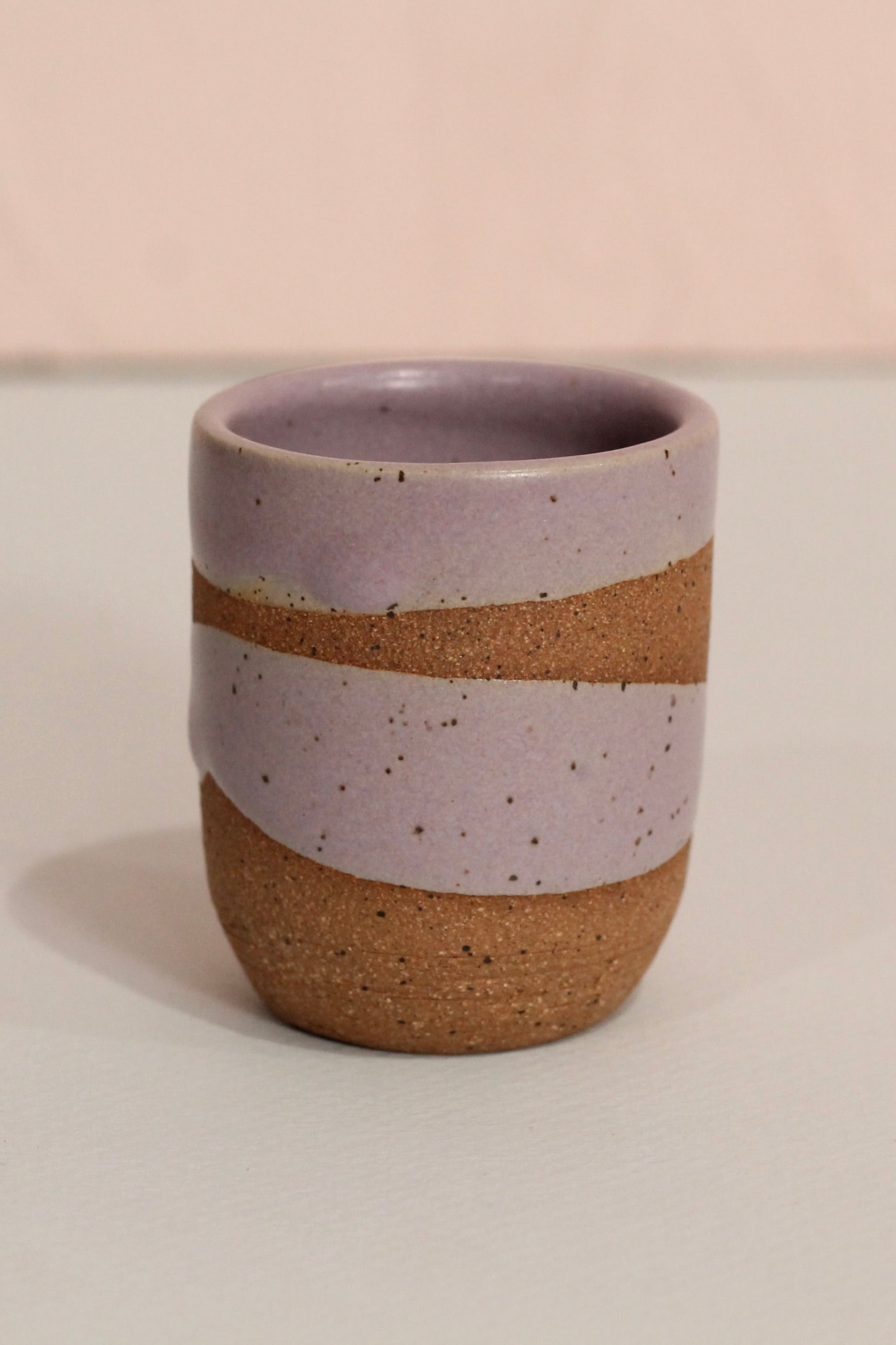 Ceramic cup with two-tone design on a plain background ©Christina Kosinski