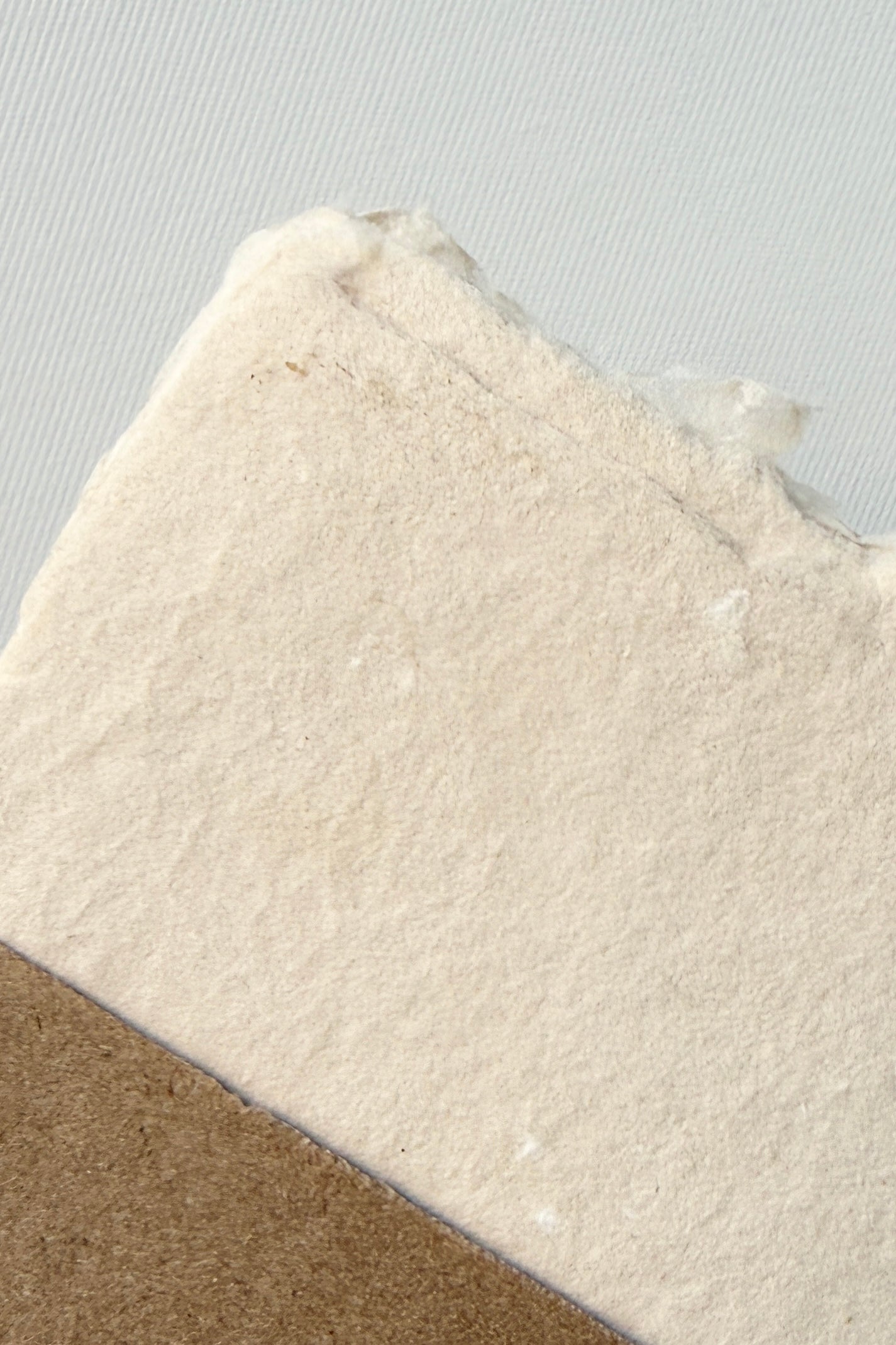 Handmade Buff Paper Sheet Set in A2 by Sustainable Paper + Craft showing a detail of the fibers on white surface ©Sprout Home