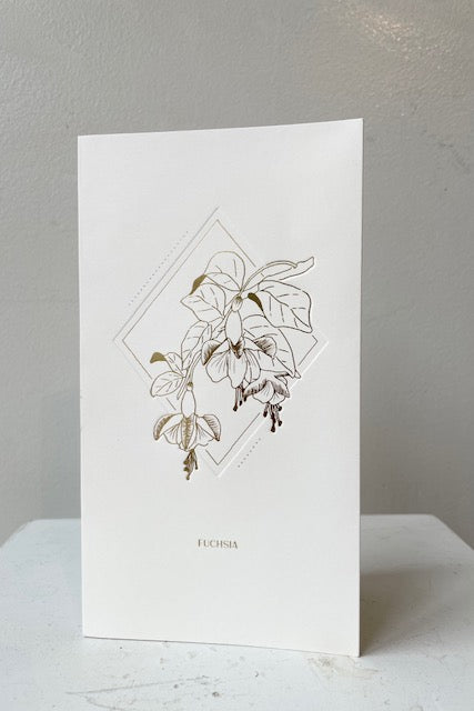 Front of pop up card with gold embossed Fuchsia Flower design, text says Fuchsia