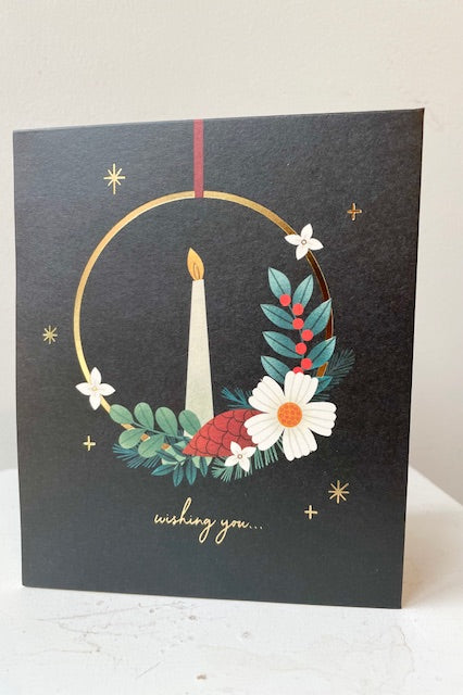 Pop up card with gold candle ring and winter greenery on black background. Text says Wishing you...