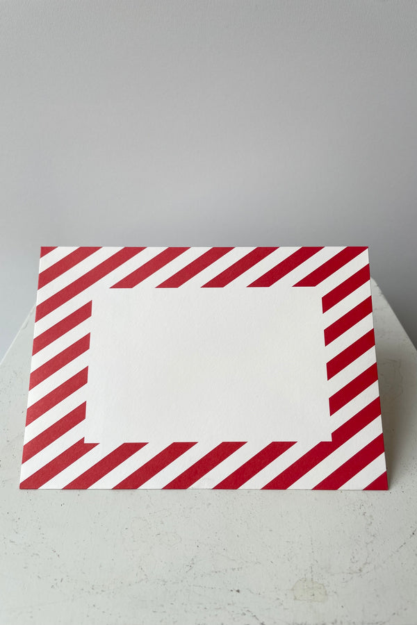Red and white striped envelope with blank white recrtangle on face of envelope.